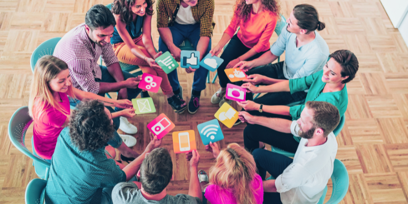 circle of people holding icons, as if asking the question: Who owns social media accounts for a business?